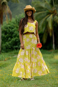 woman wearing a bright green orchid print maxi skirt with matching top