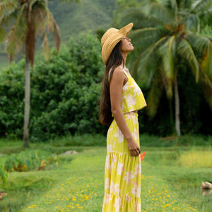woman wearing a bright green orchid print maxi skirt with matching top