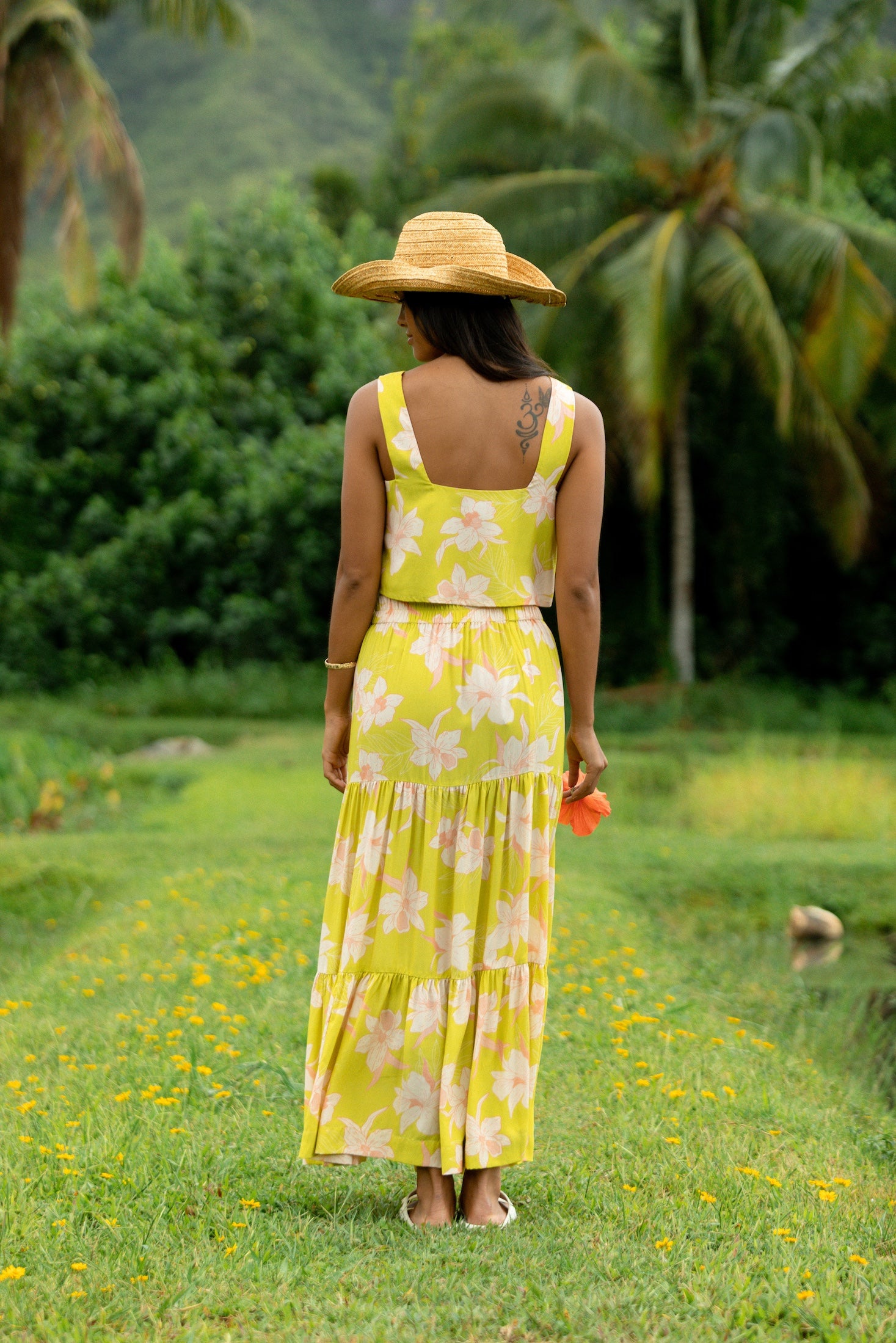 woman wearing a bright green orchid print maxi skirt with matching top