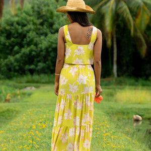 woman wearing a bright green orchid print maxi skirt with matching top