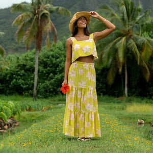 woman wearing a bright green orchid print cropped top with matching maxi skirt