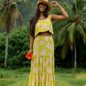 woman wearing a bright green orchid print maxi skirt with matching top