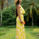 woman wearing a bright green orchid print cropped top with matching maxi skirt