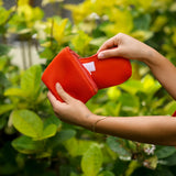 woman holding expandable puakenikeni printed neoprene pouch with detachable mini pouches