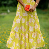 woman wearing a bright green orchid print maxi skirt with matching top