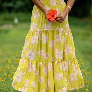 woman wearing a bright green orchid print maxi skirt with matching top