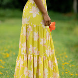 woman wearing a bright green orchid print maxi skirt with matching top