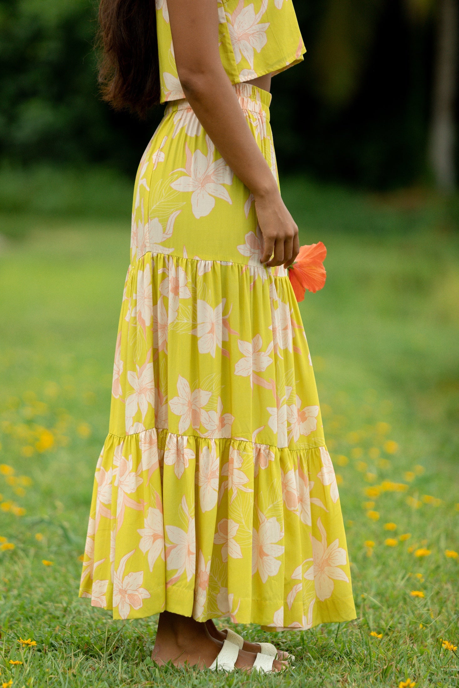 woman wearing a bright green orchid print maxi skirt with matching top