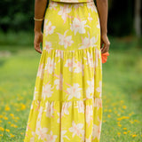 woman wearing a bright green orchid print maxi skirt with matching top