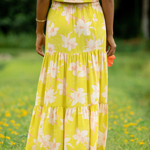 woman wearing a bright green orchid print maxi skirt with matching top