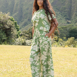 woman wearing green matching top and pant set with native Hawaiian plants 