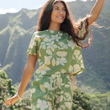 woman wearing green matching top and pant set with native Hawaiian plants 
