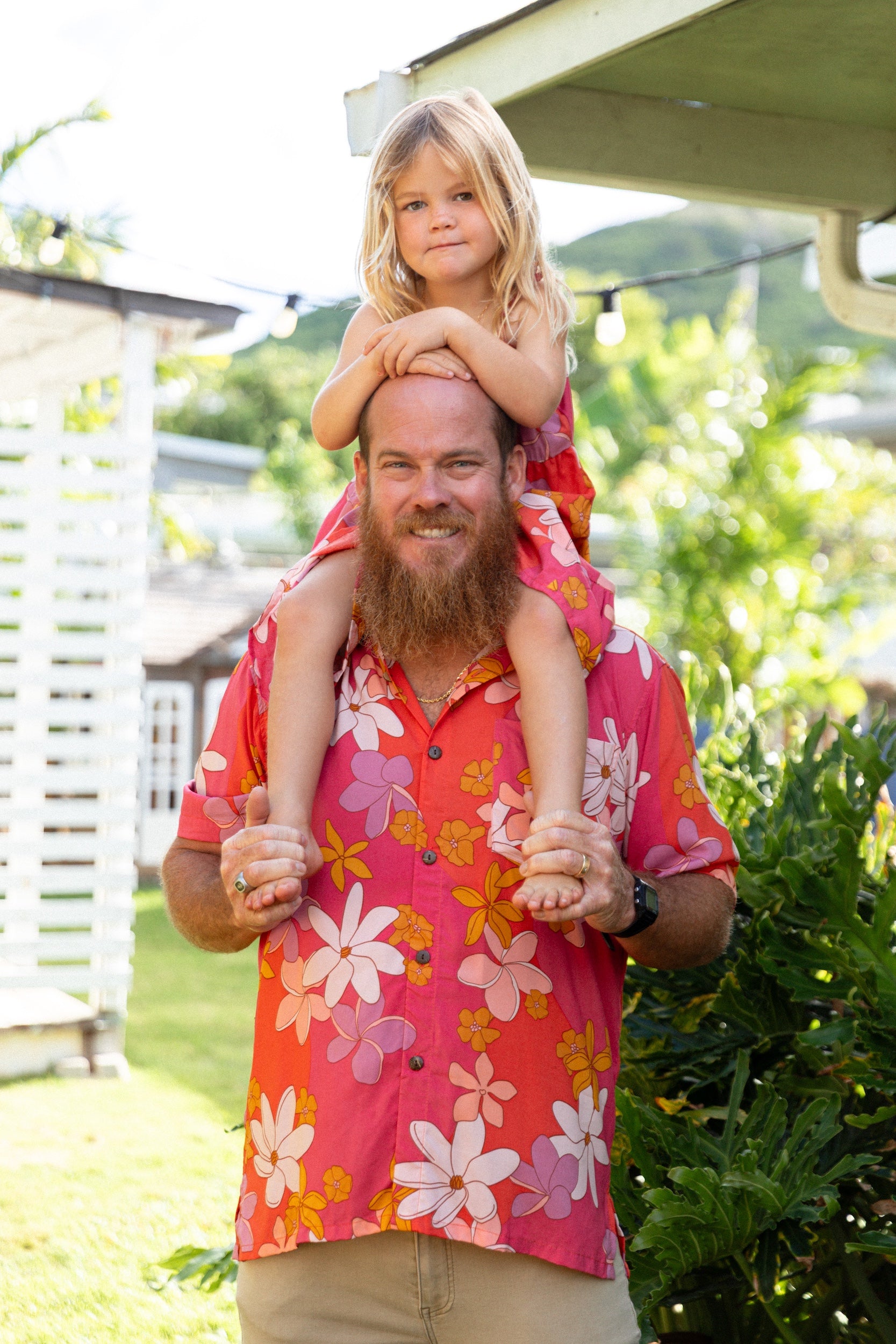 man wearing pink aloha button up shirt with retro flower pattern