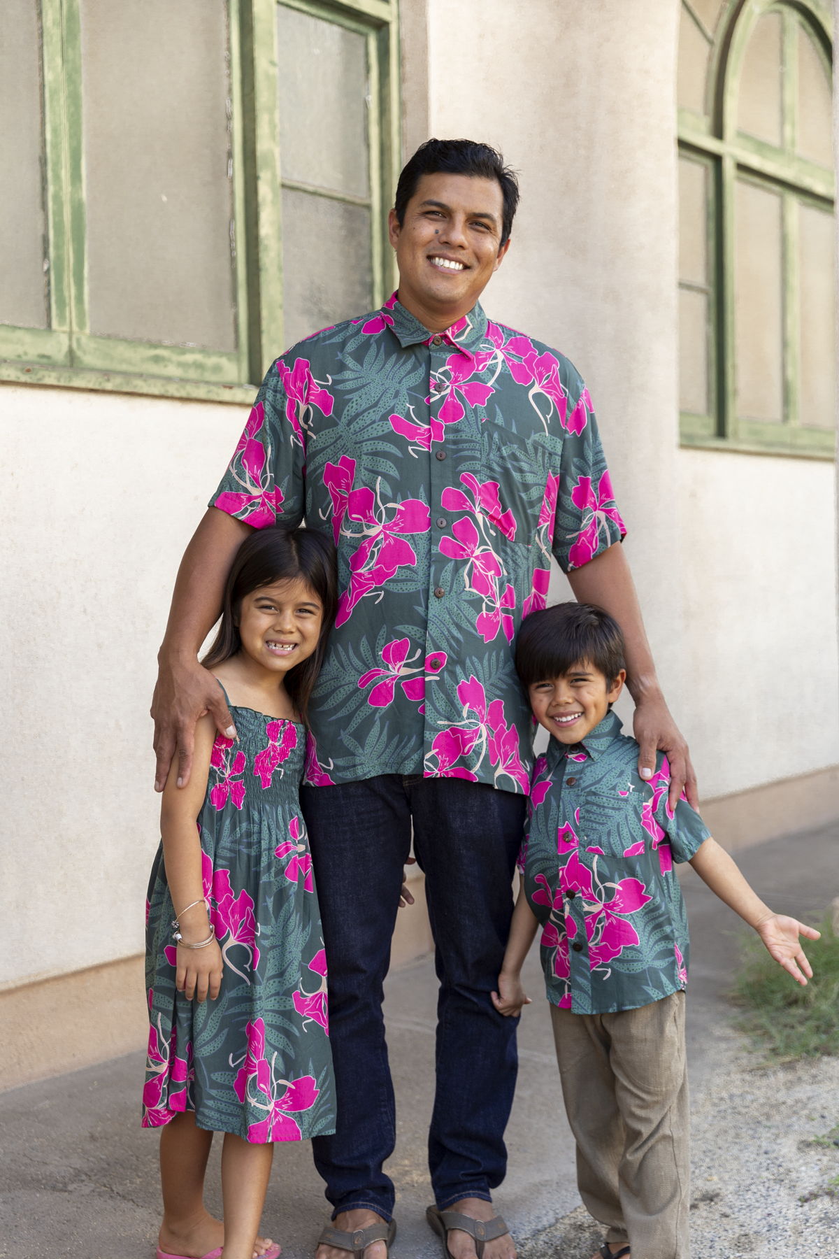little girl with brown hair wearing a smocked spaghetti strap dress with fern and ginger print