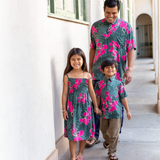 little girl with brown hair wearing a smocked spaghetti strap dress with fern and ginger print