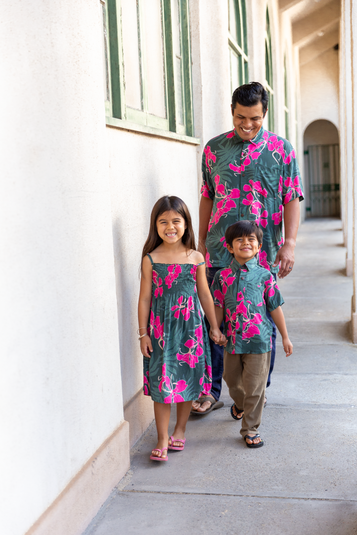 little girl with brown hair wearing a smocked spaghetti strap dress with fern and ginger print