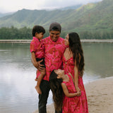 Family in brown aloha attire with large pink floral print