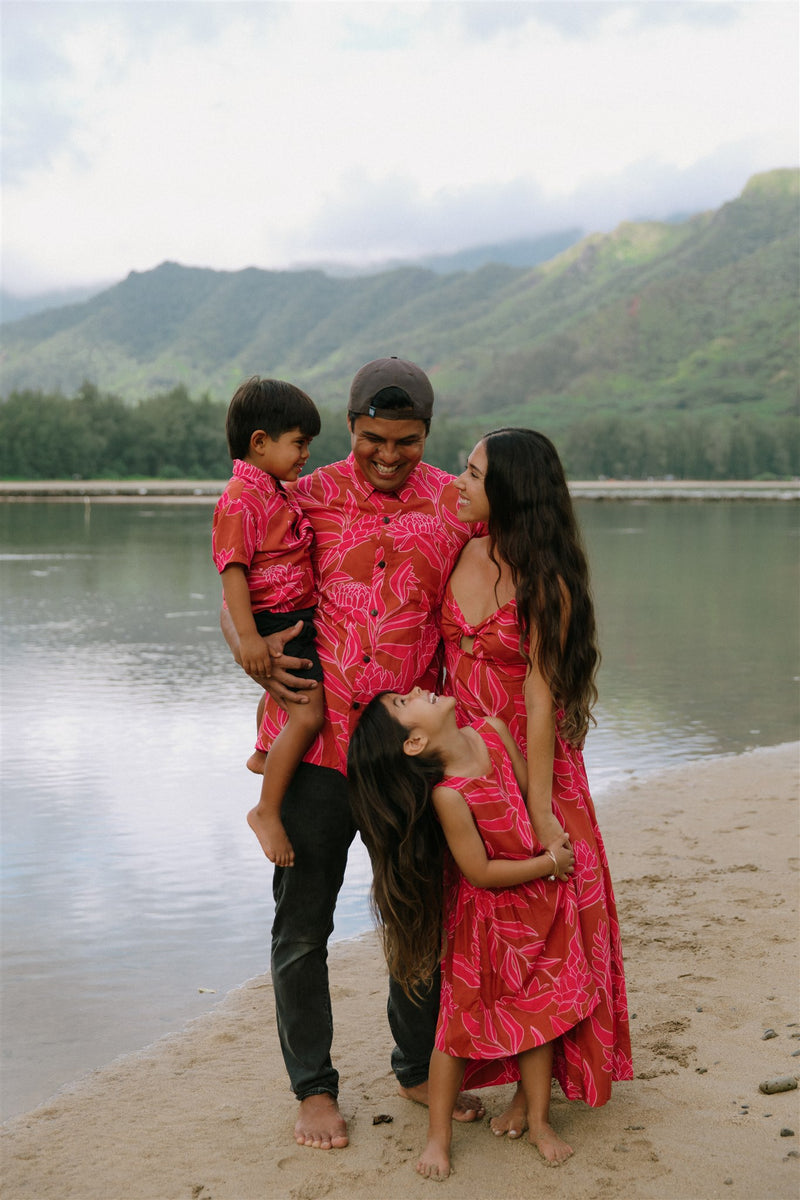 Family in brown aloha attire with large pink floral print