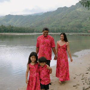 Family in brown aloha attire with large pink floral print