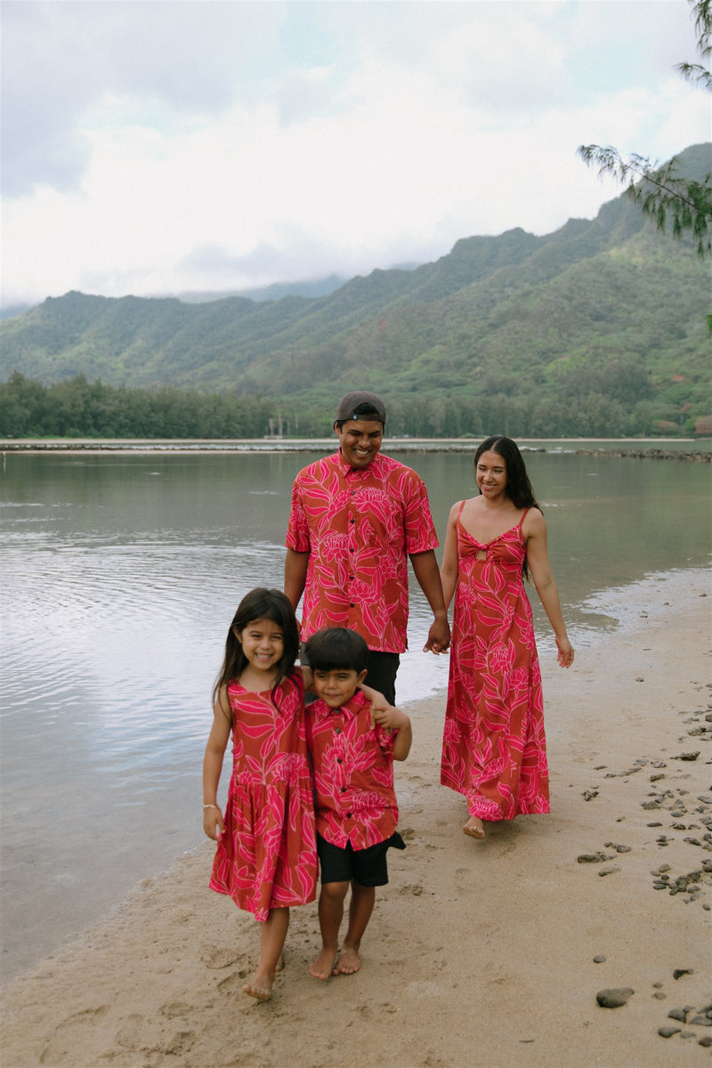 Family in brown aloha attire with large pink floral print