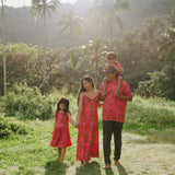 Family in brown aloha attire with large pink floral print