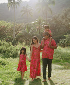 Family in brown aloha attire with large pink floral print