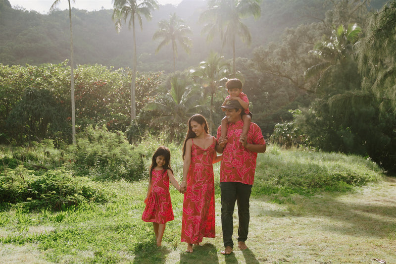 Family in brown aloha attire with large pink floral print