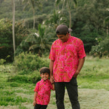Boy and man in brown button up shirt with large pink floral print 
