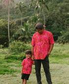 Boy and man in brown button up shirt with large pink floral print 