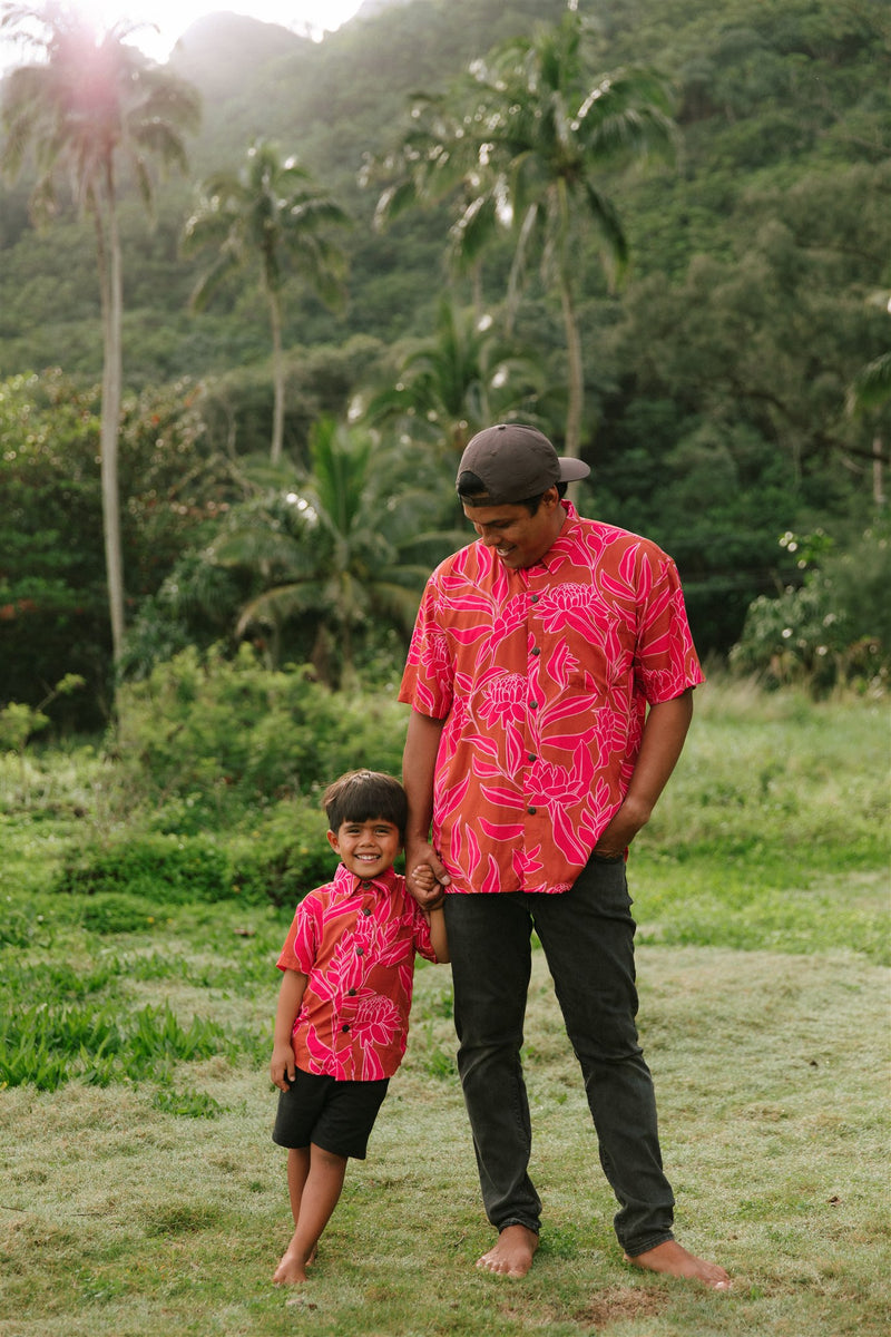 Boy and man in brown button up shirt with large pink floral print 