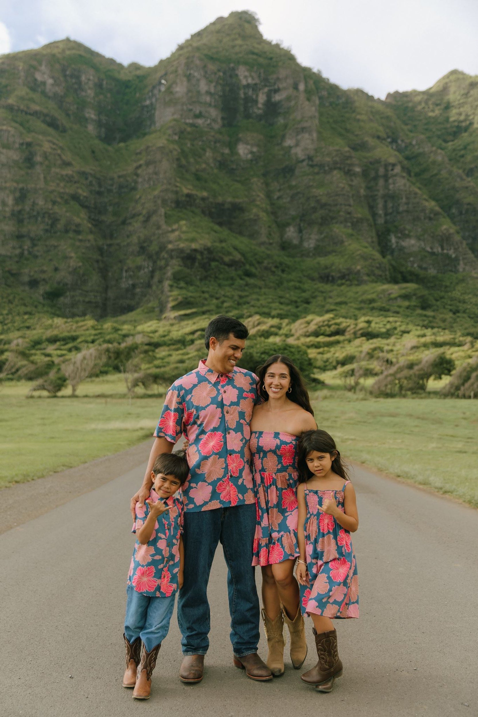 man wearing a nay button up aloha shirt with bright pink hibiscus print