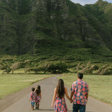 man wearing a nay button up aloha shirt with bright pink hibiscus print