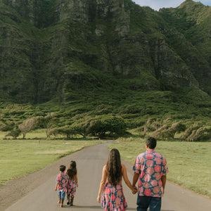 man wearing a nay button up aloha shirt with bright pink hibiscus print