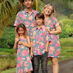 family wearing matching teal aloha wear with floral print