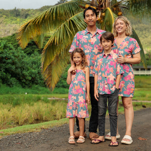 family wearing matching teal aloha wear with floral print
