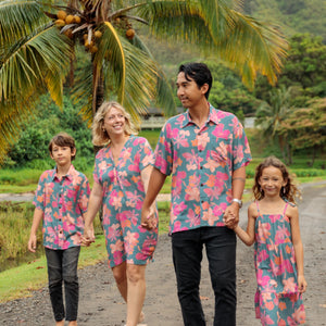 family wearing matching teal aloha wear with floral print