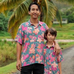 family wearing matching teal aloha wear with floral print