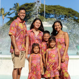 man wearing terracotta colored aloha shirt with large purple and yellow flower print