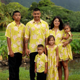 family wearing matching bright green aloha wear with orchid print