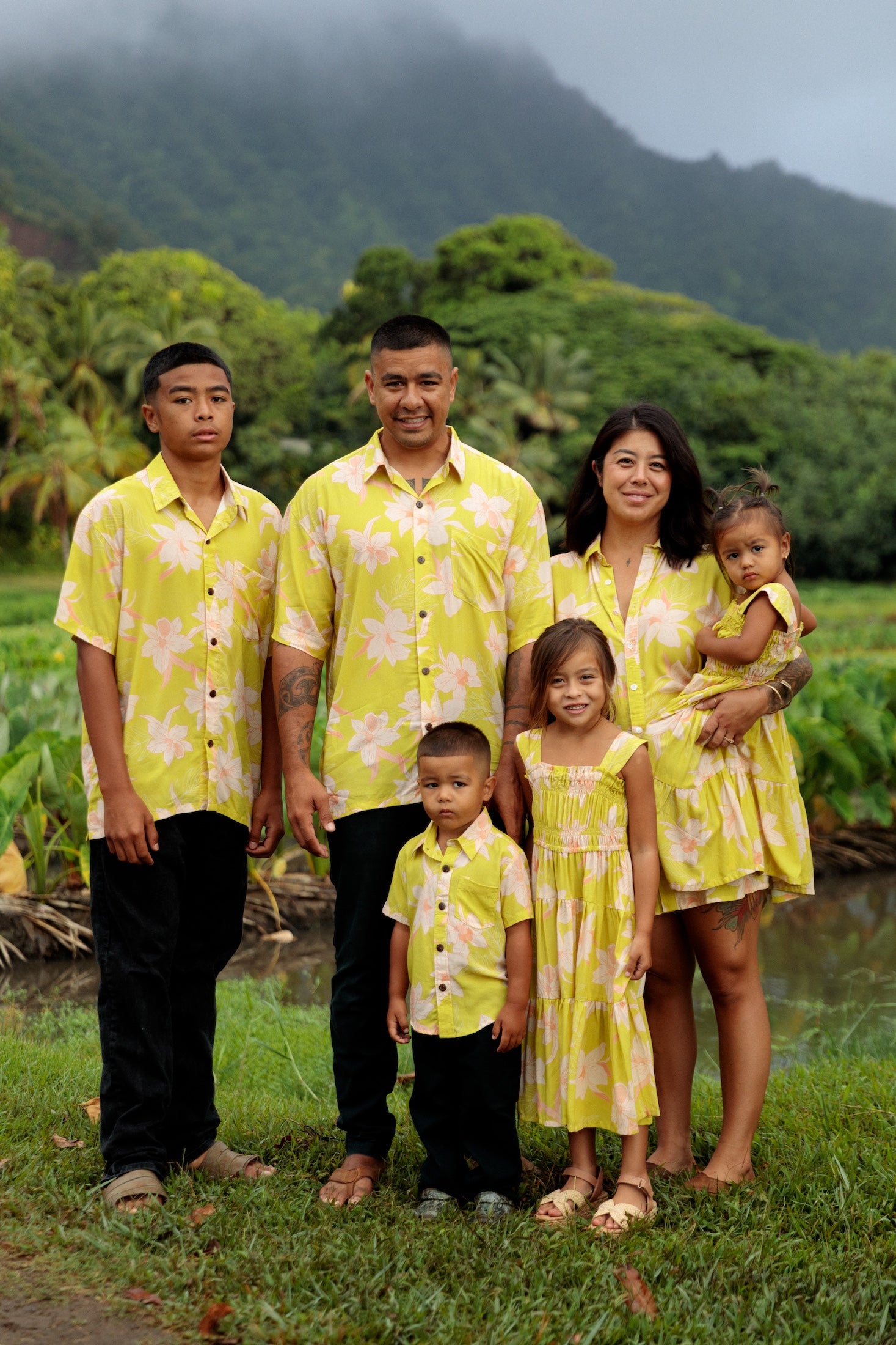family wearing matching bright green aloha wear with orchid print