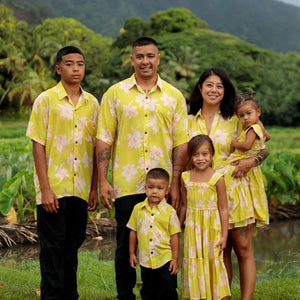 family wearing matching bright green aloha wear with orchid print