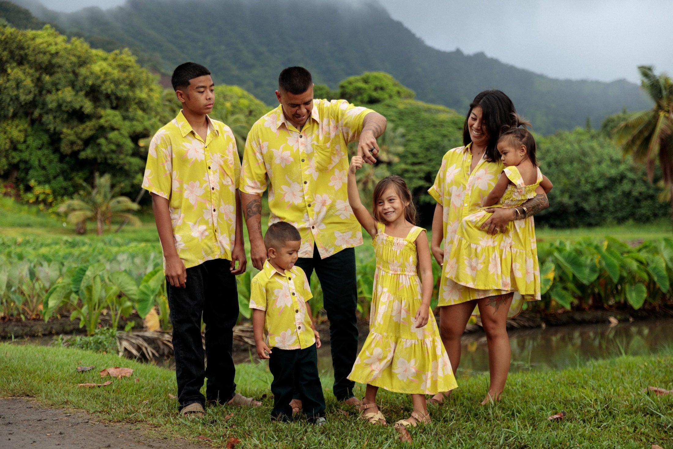 family wearing matching bright green aloha wear with orchid print