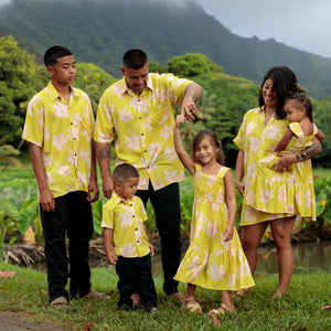 family wearing matching bright green aloha wear with orchid print