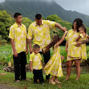 family wearing matching bright green aloha wear with orchid print