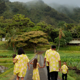 family wearing matching bright green aloha wear with orchid print