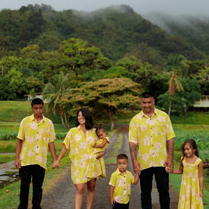 family wearing matching bright green aloha wear with orchid print