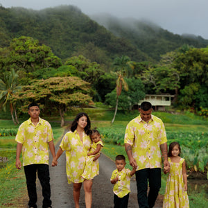 family wearing matching bright green aloha wear with orchid print