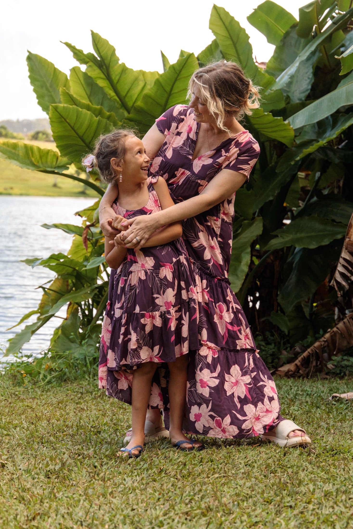 little girl wearing dark purple dress with flutter sleeve and orchid print
