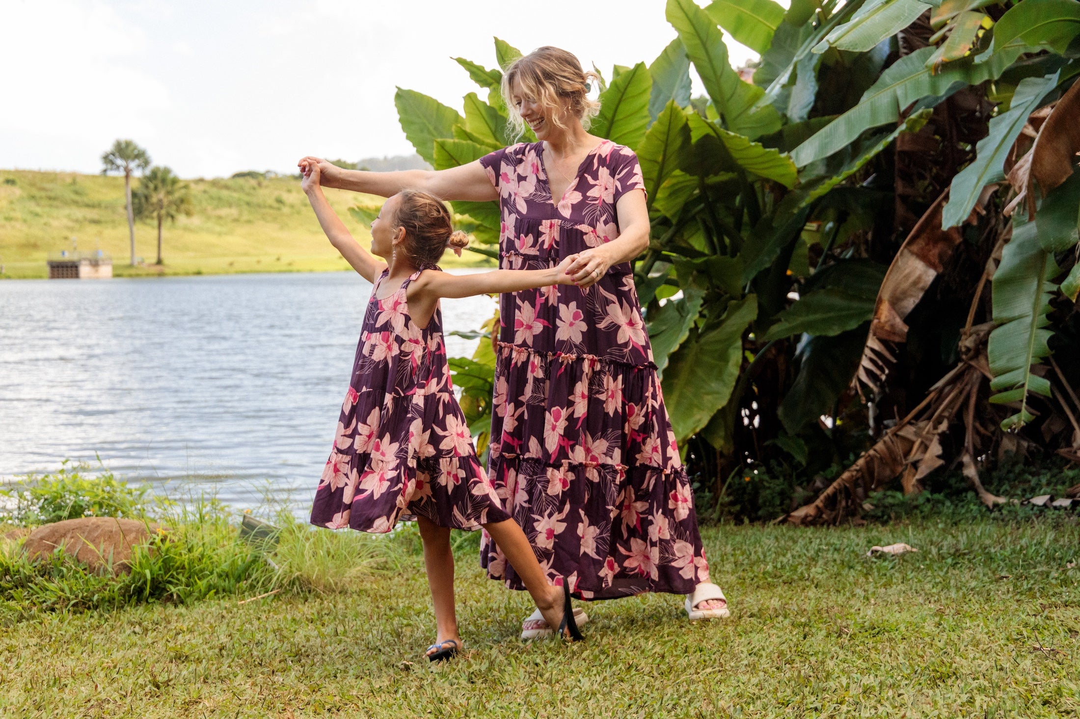 little girl wearing dark purple dress with flutter sleeve and orchid print