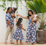 little girl wearing a tiered maxi dress in navy and pink hibiscus print.